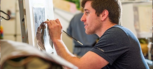 Student in classroom drawing.