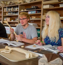 Students holding materials in a classroom.