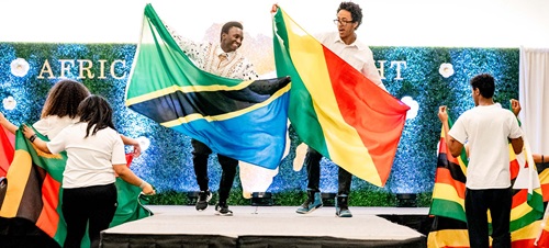 Students on Stage Holding Flags At African Night