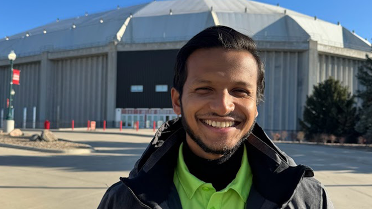 Abdullah Al Hossain smiles while standing in front of the USD DakotaDome.