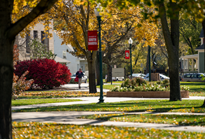 student walking in front of Arts and Sciences building in the fall