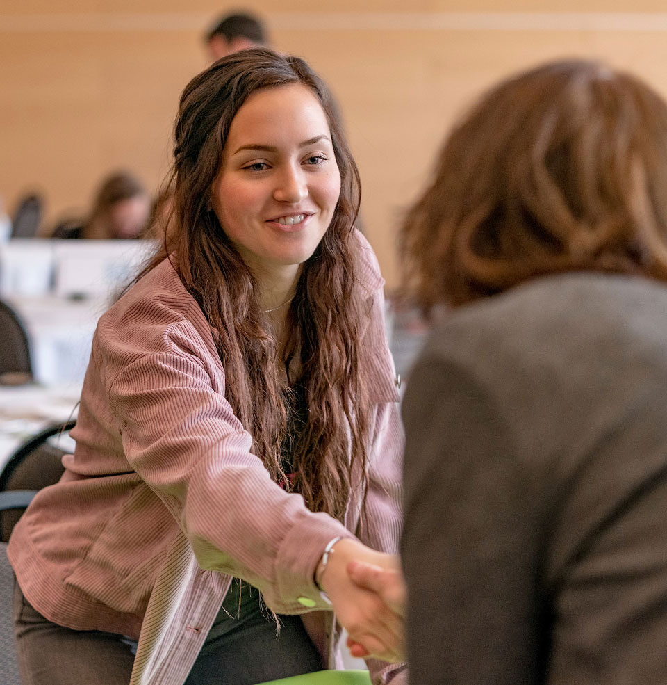 Females shaking hands across a table