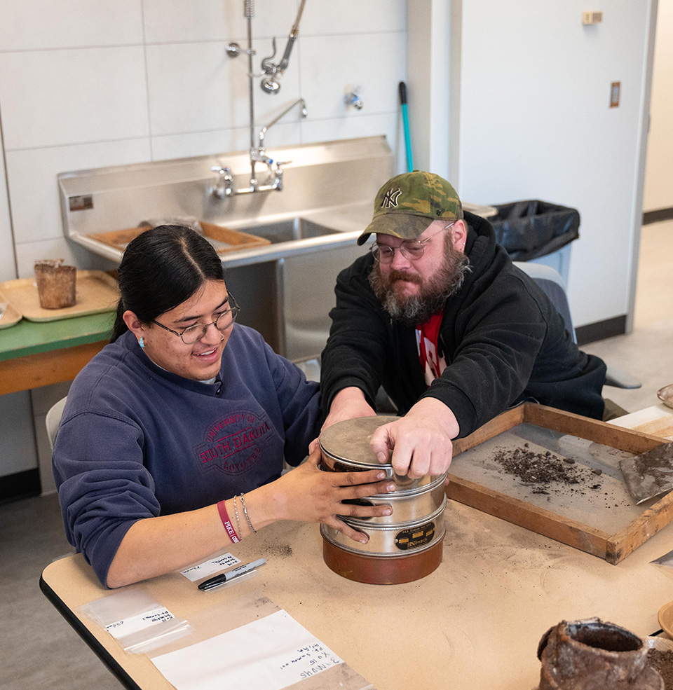 Student and teacher working with rocks in the new archeology lab.