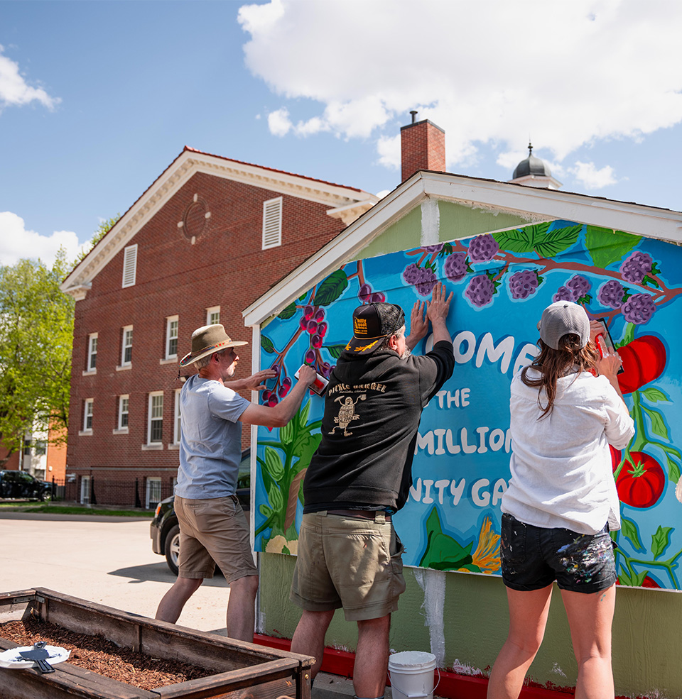 Group of people setting up a mural for the Vermillion community garden