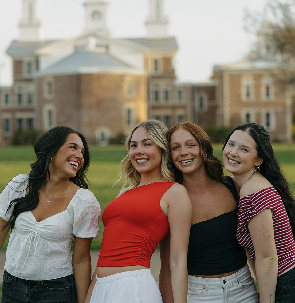 4 friends standing in front of Old Main