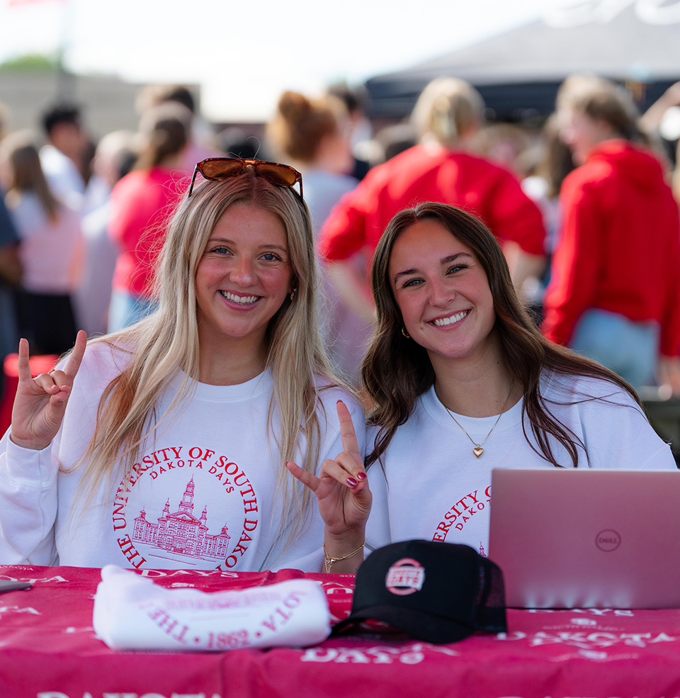 students at the organization fair holding up yote hands