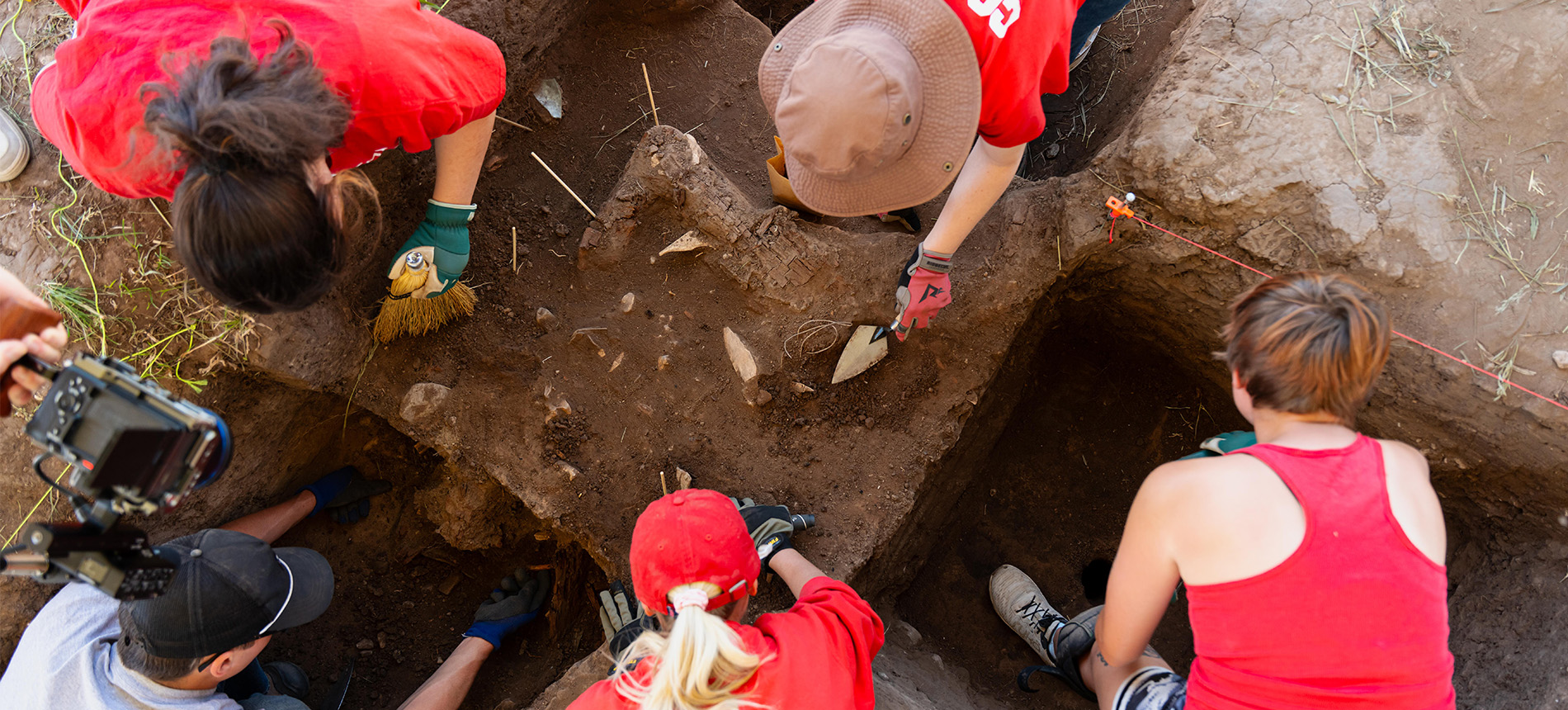 top view of 4 students digging a hole