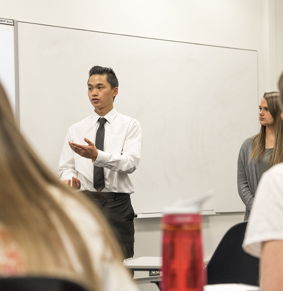 Faculty and students in a class discussing a communication topic