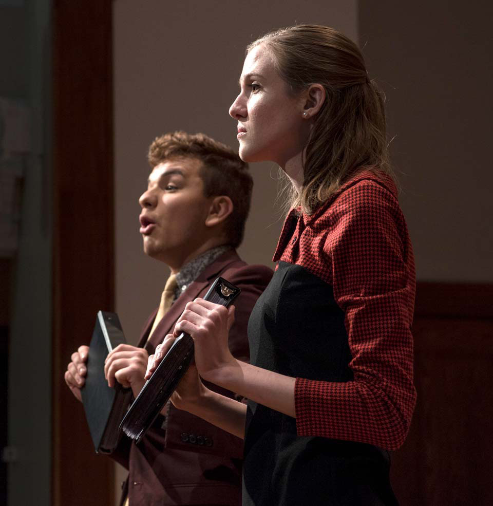 Two students on a stage, communicating