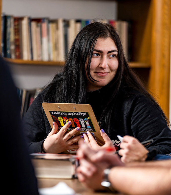 An English student smiling holding a book.