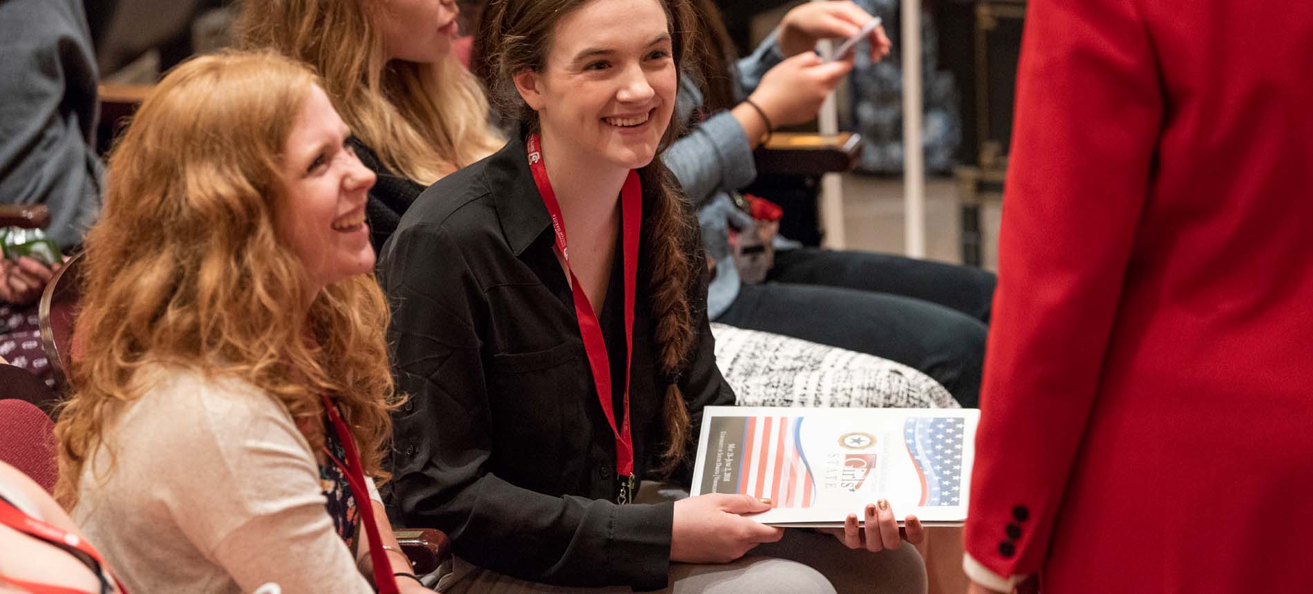 Students smiling at a public event.