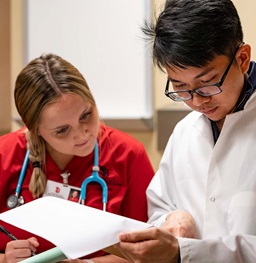 Health science students with medical gear review hospital charts.