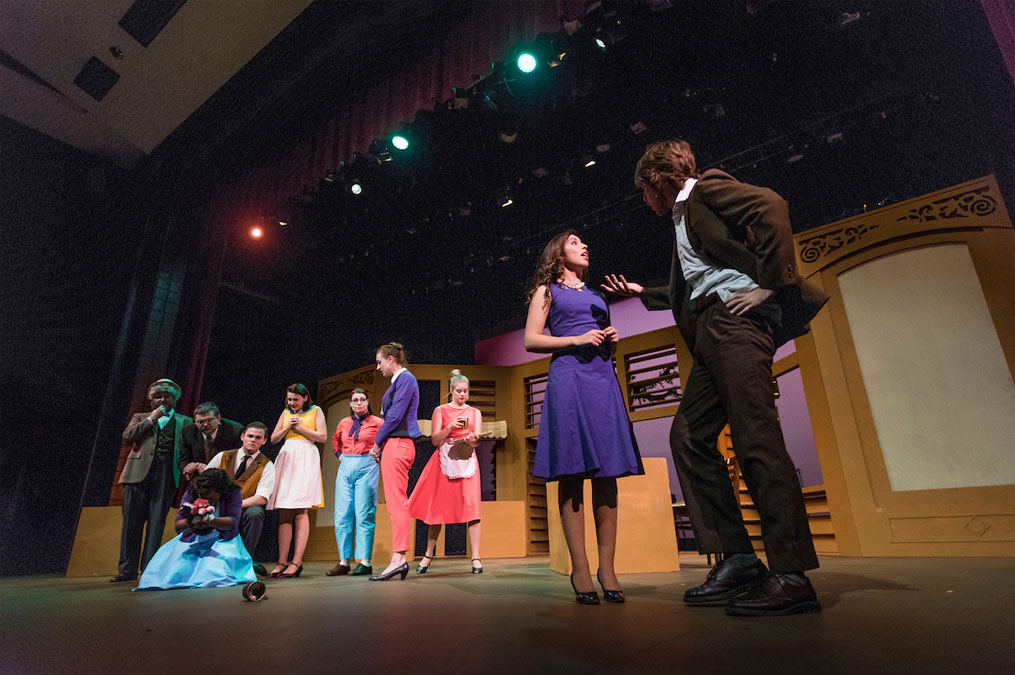 Theatre production on stage with actors wearing clothes from the seventies or eighties