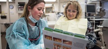 A dental hygiene student in a room with a faculty member.