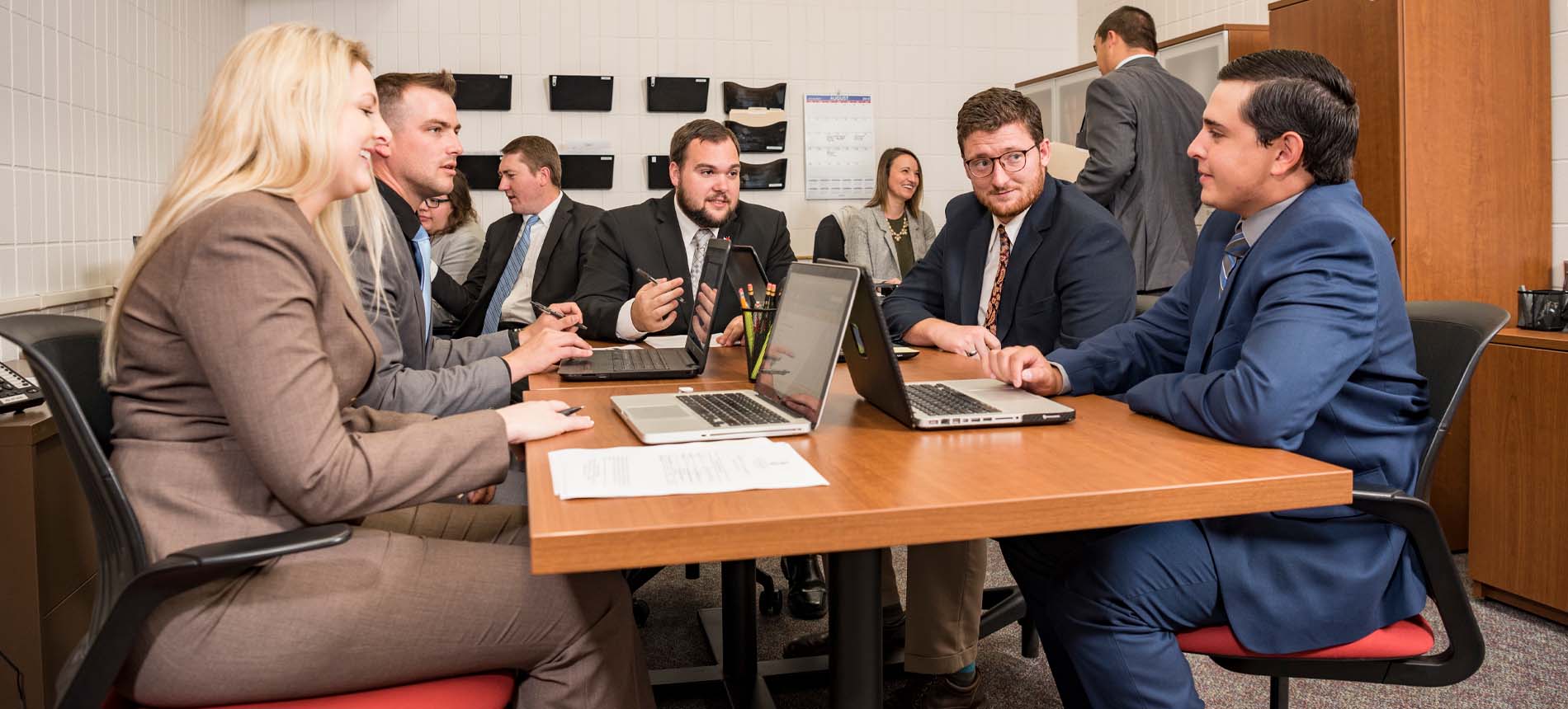 Group of Law Students Sitting Around Table with Laptops.