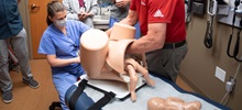 Female in Blue Scrubs Delivering a Baby in a Simulation.