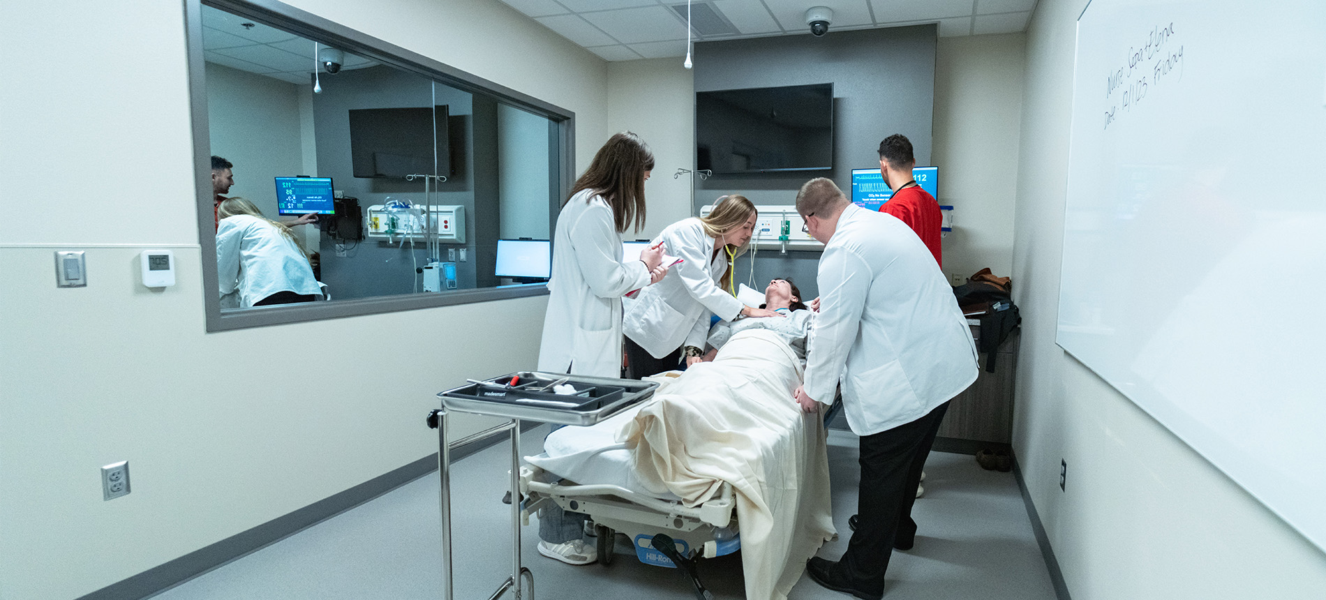 Medical students standing around an operating table in the Parry Center. 