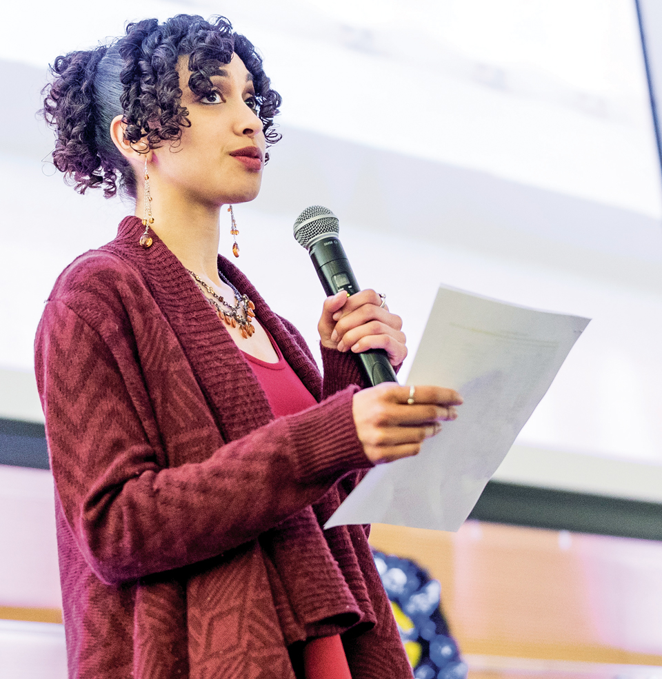 A student with a microphone reading a speech.