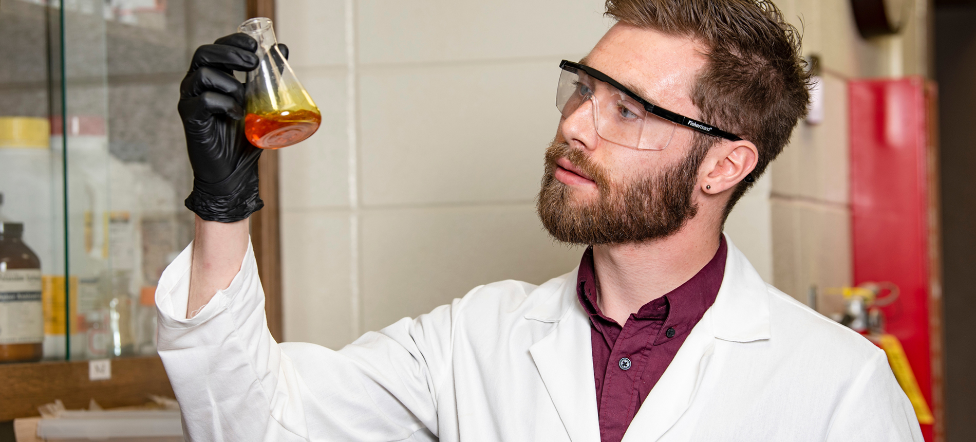 A PhD student in a lab coat in the lab.