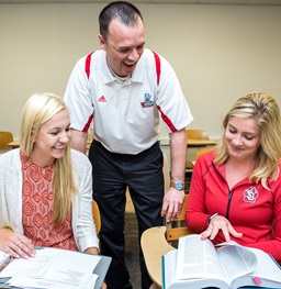 Two Students Talking with their Professor.