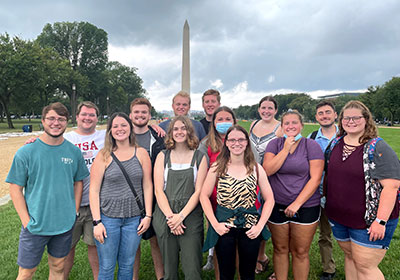A group of students posing in front of the Washington Monument.