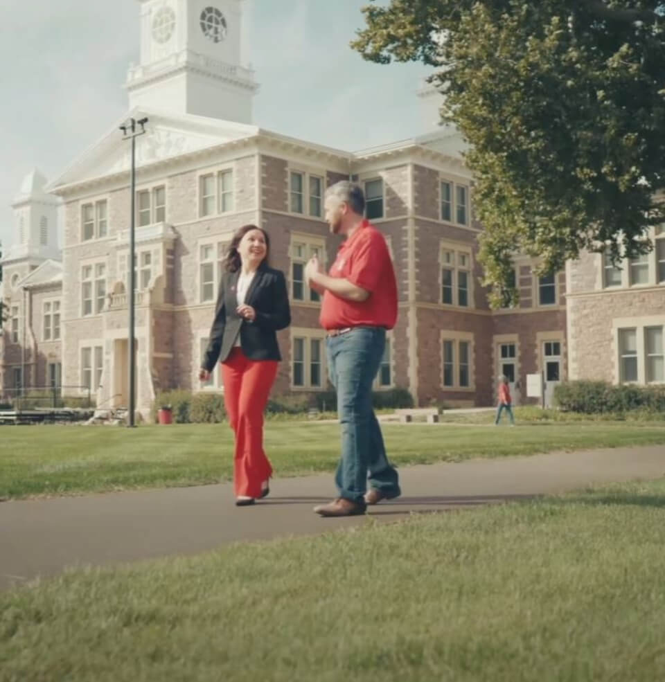 Joshua Gaines walking and talking with a faculty member.