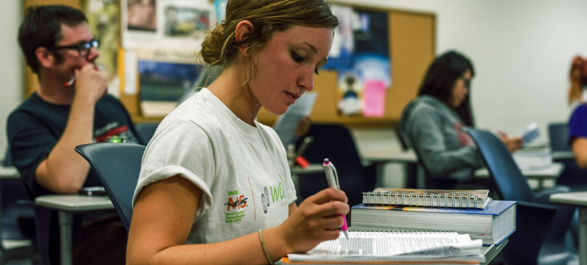 A student taking notes during a lecture.