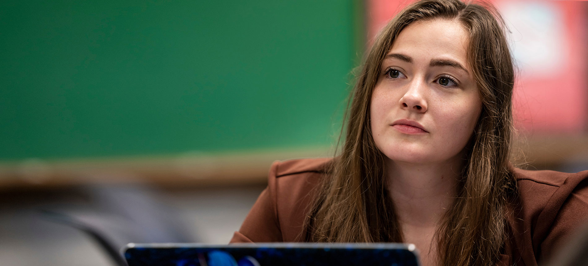 A student on her laptop in a classroom.