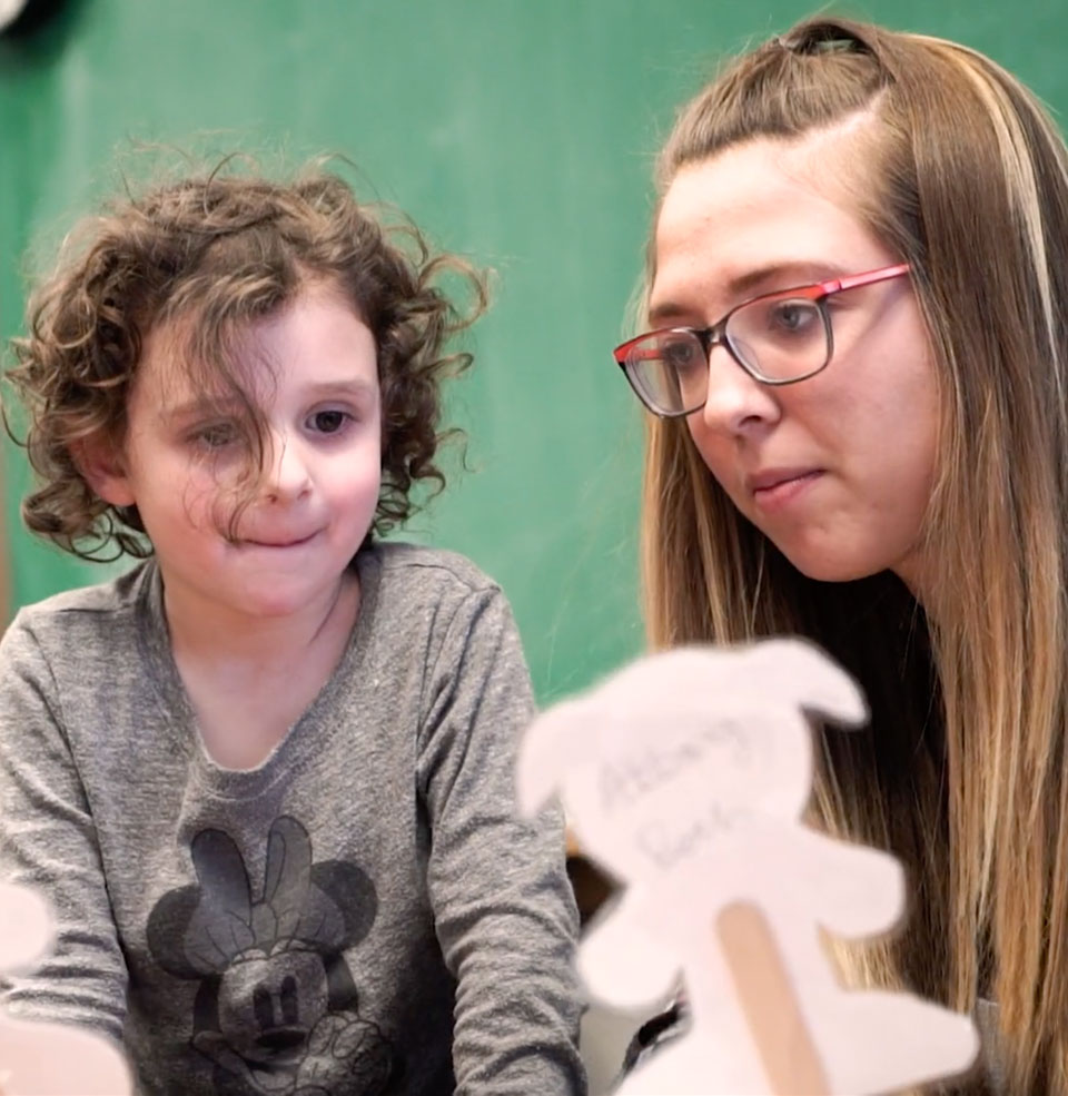 A teacher showing a child an art craft.
