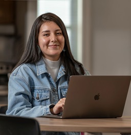 A student sitting in a study lounge with their laptop