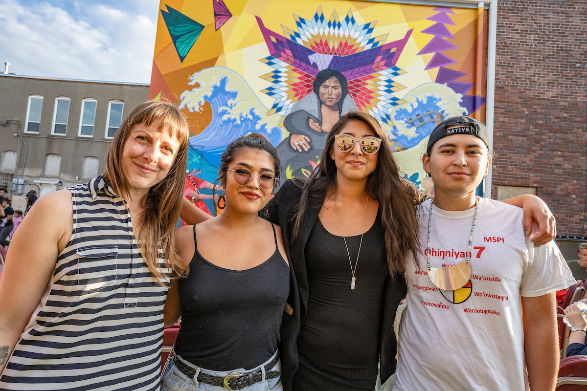 Students in front of a Native American art mural