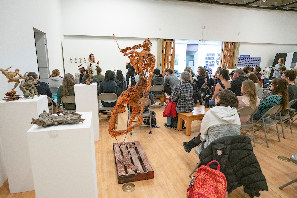 Art review with an artist presenting to a seated class in a gallery