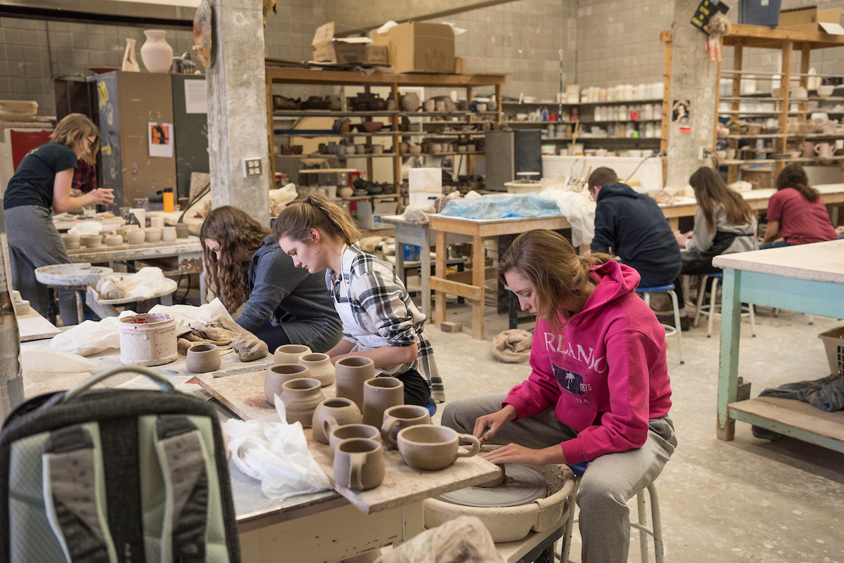 Ceramics class with students throwing pottery