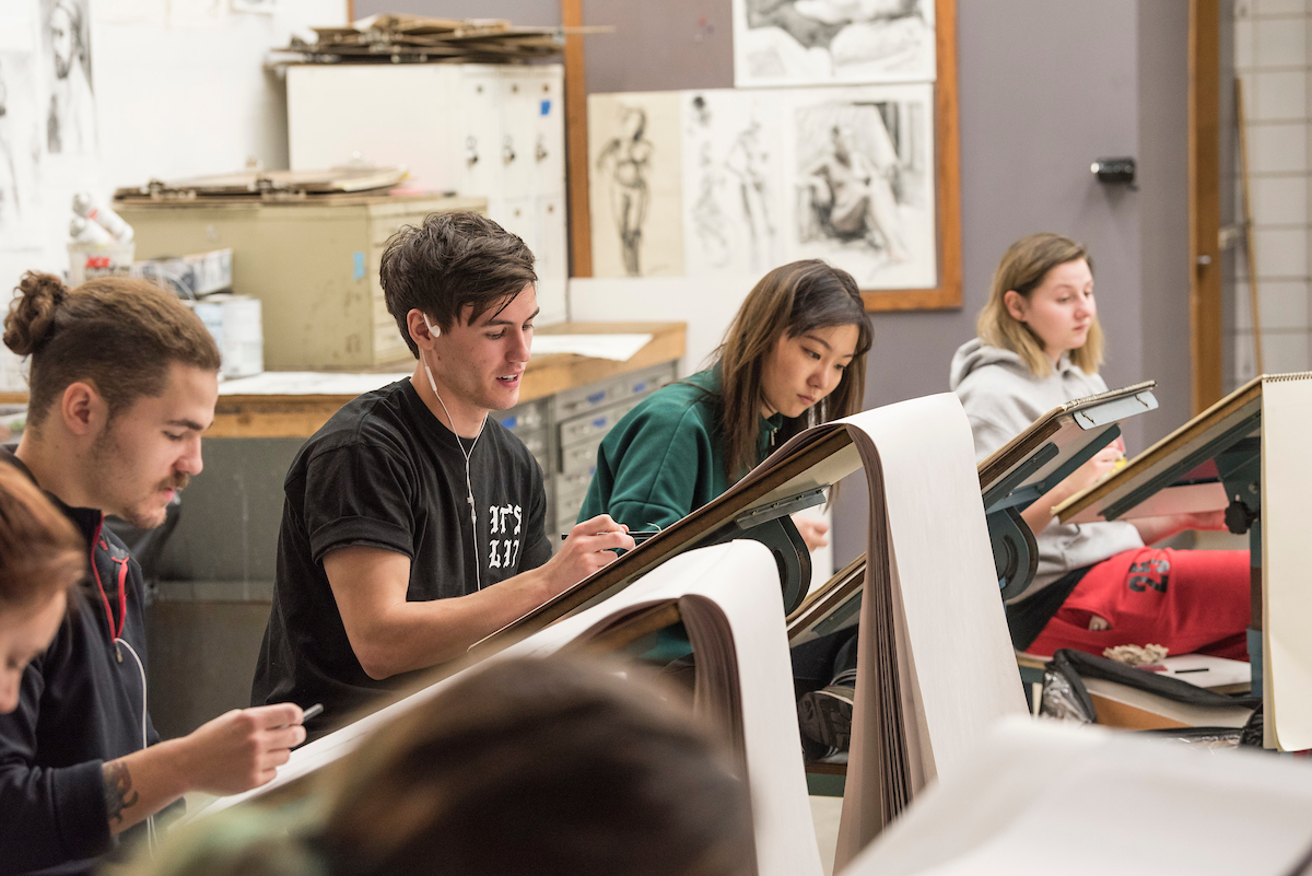 Art class with students drawing on sketch pads