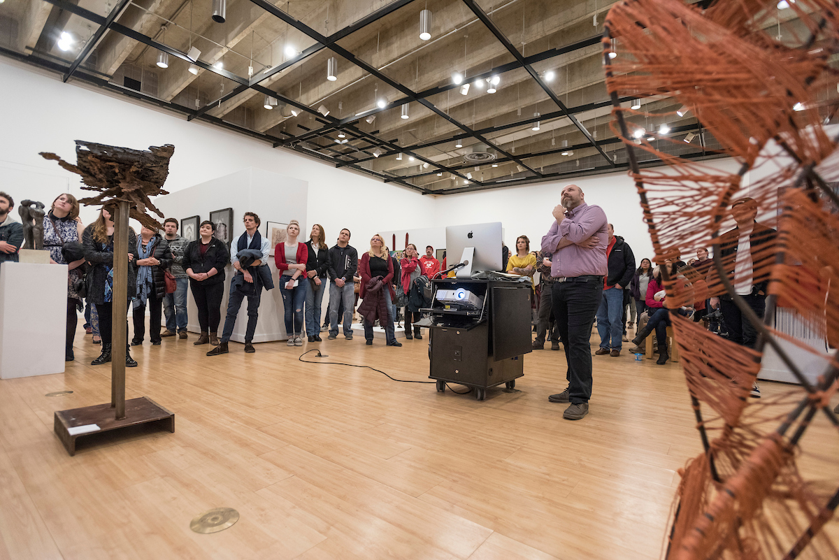 Presentation in a gallery featuring tall metal sculptures