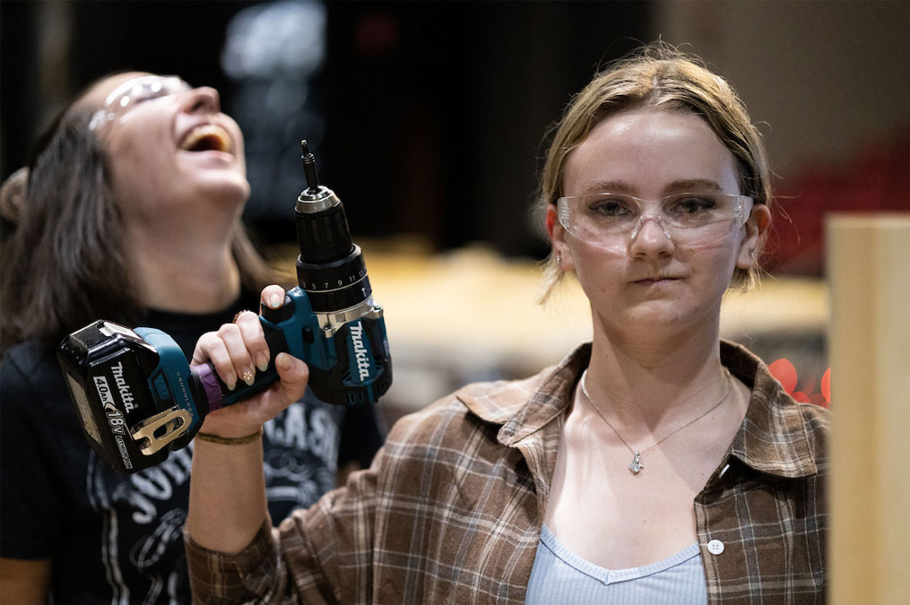 Students having fun and laughing while building the theatre production scene