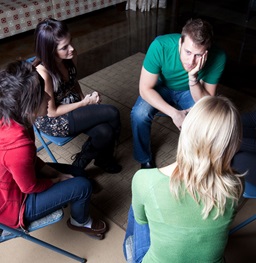 People sitting a circle talking.