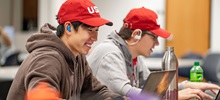 Two USD Students studying on their laptops in the ID Weeks library.