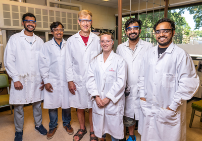Students in lab coats posing in the Sereda Lab.