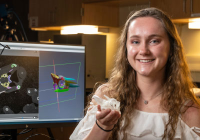 Student Alexis Slack smiling in front of her 3D modeling work.