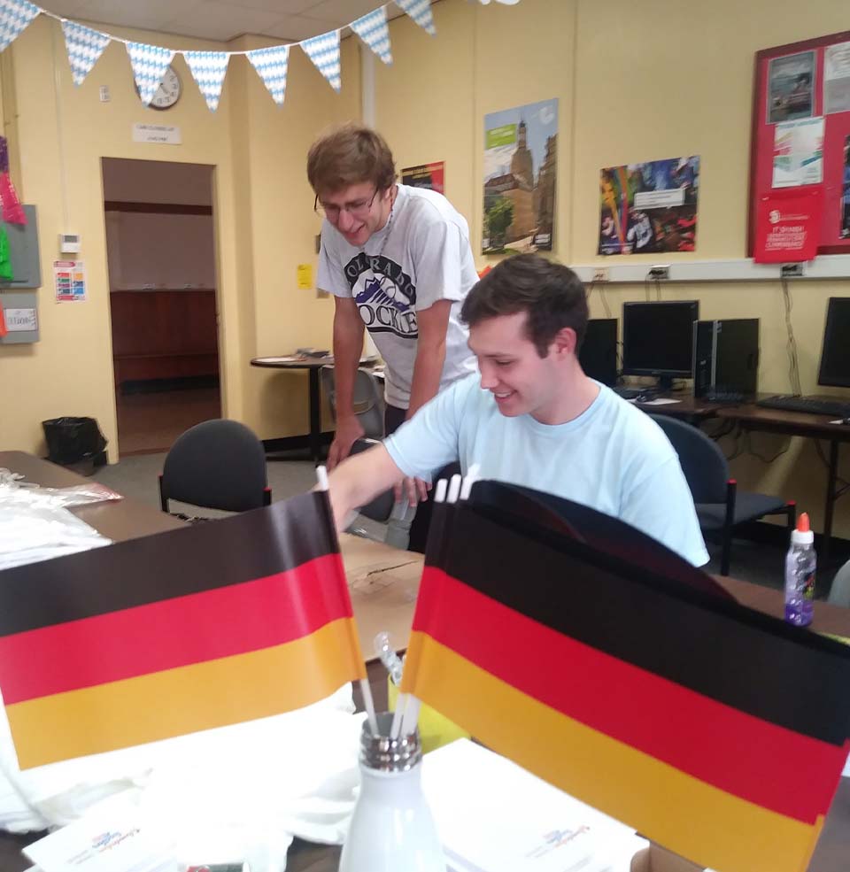 Two Students in a Classroom with German Flags.