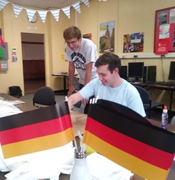 Two Students in a Classroom with German Flags.