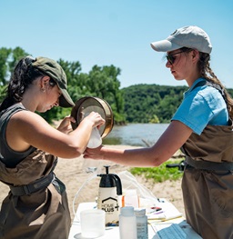 Students conducting field research by a river.