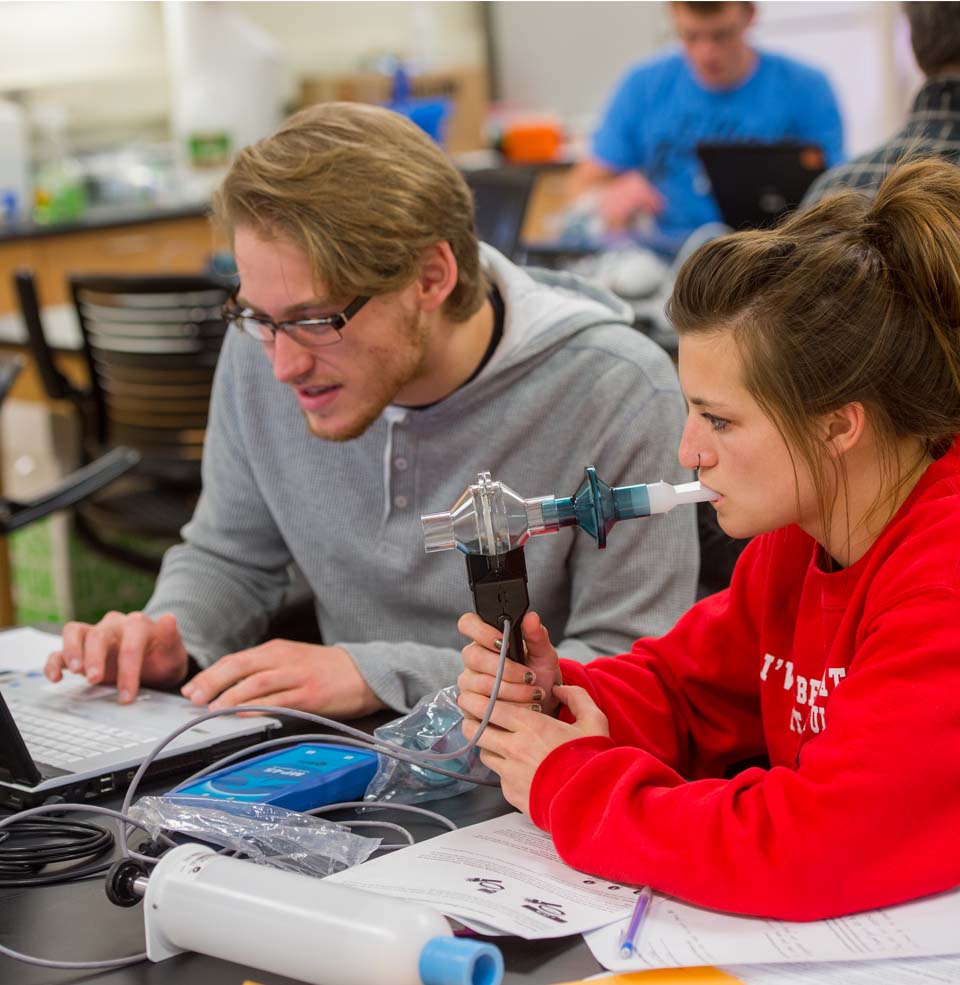 Male and female student working with breathalyzer in lab