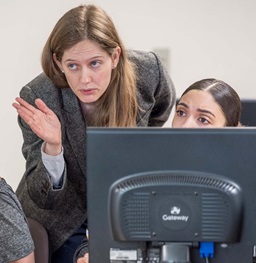 Faculty member helping a student at a computer