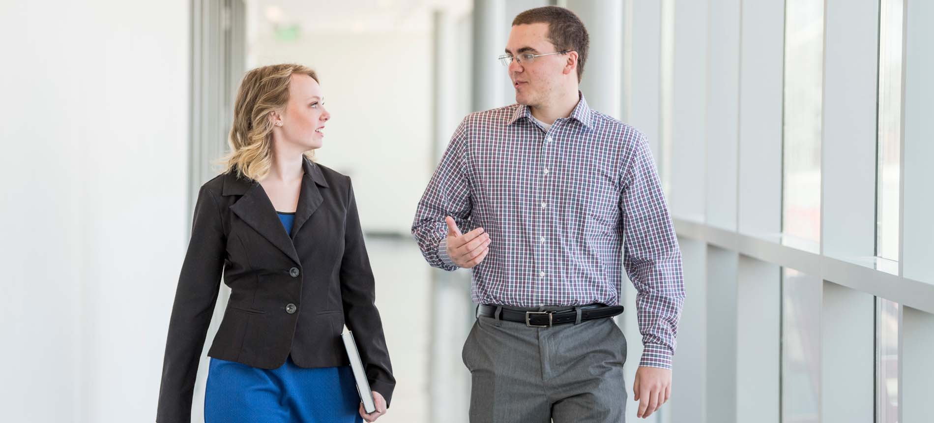 Male and Female Walking Down a Hallway