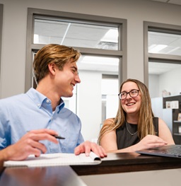 Two Beacom students doing homework together.