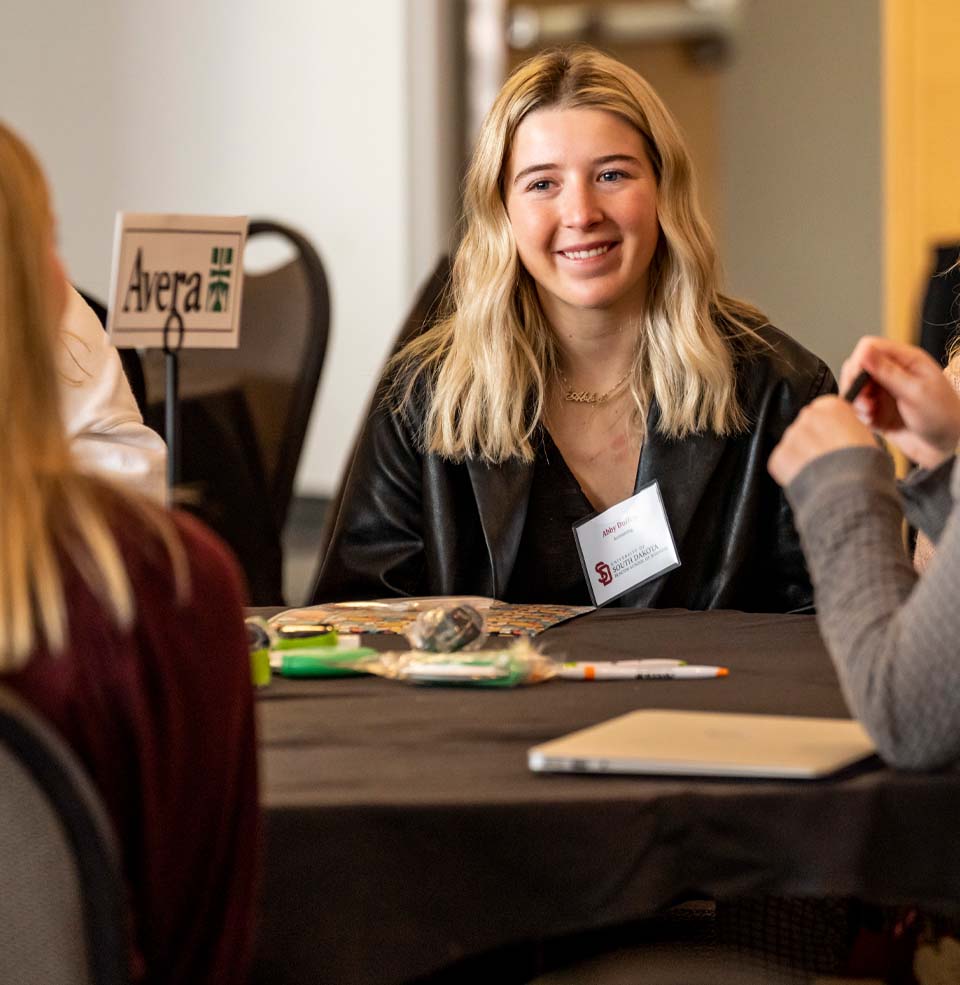 A student laughing in class during a group session.