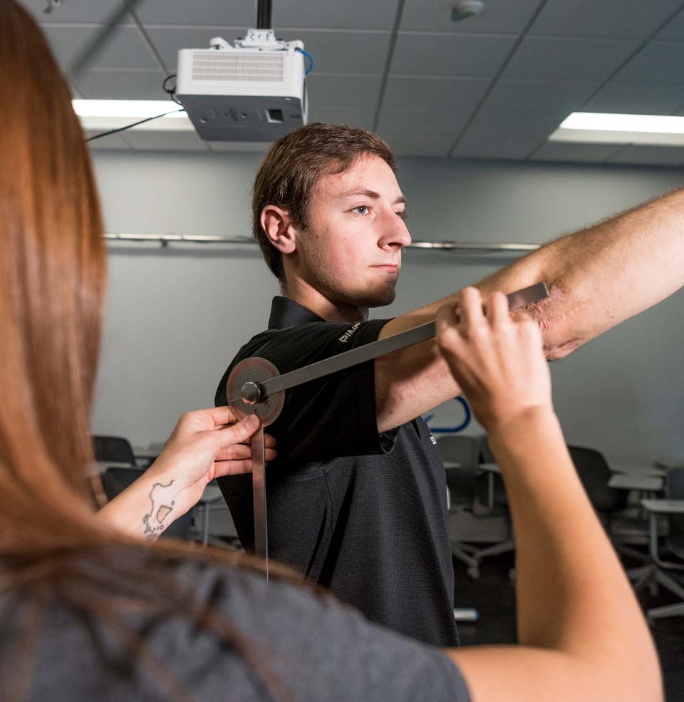 A student measuring another's arm.