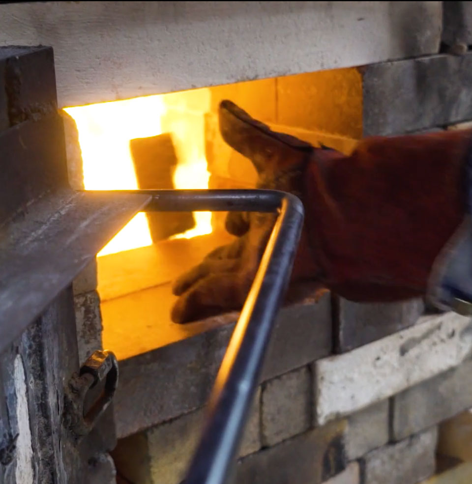 Students load wood into the wood kiln